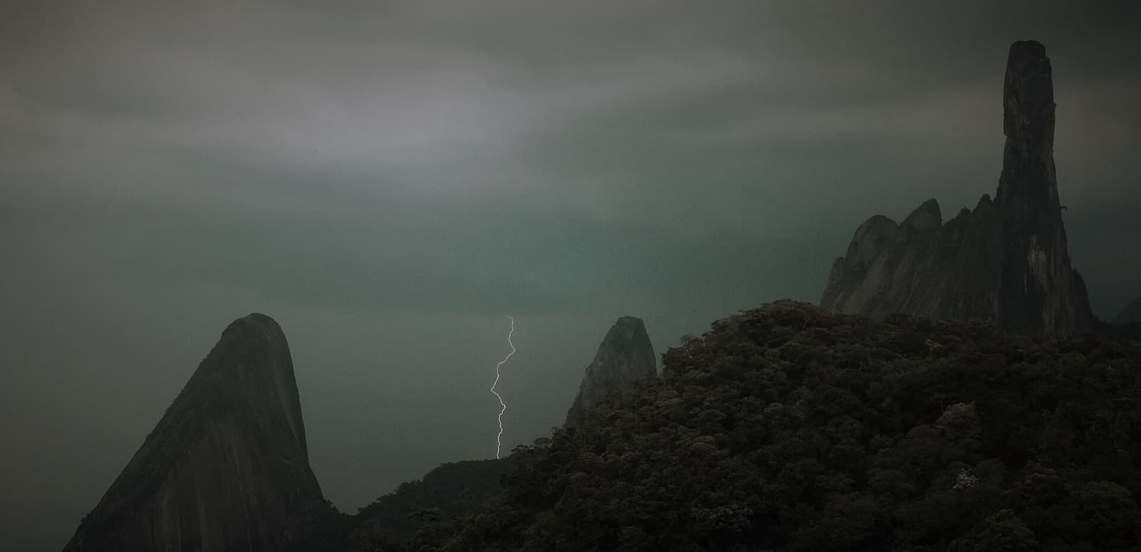 Raio caindo entre as montanhas do Complexo Dedo de Deus numa tempestade de verão