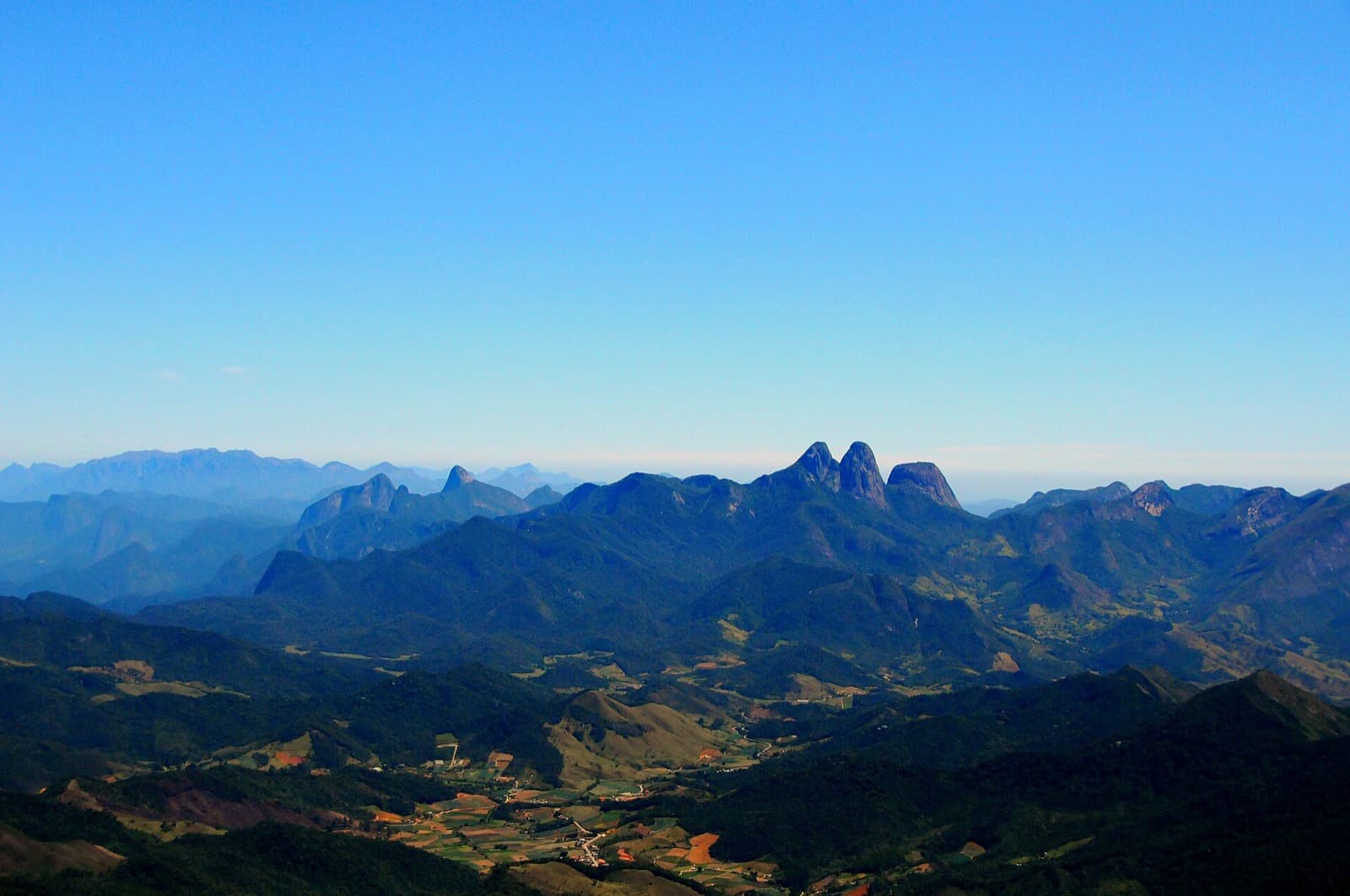 Os Três Picos de Friburgo vistos do alto do Pico da Caledônia, com um bloco de granito em primeiro plano