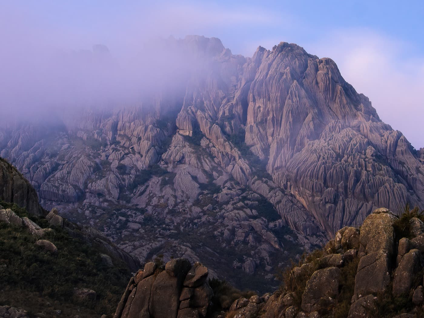 Pico das Agulhas Negras envolto em névoa rosada ao amanhecer
