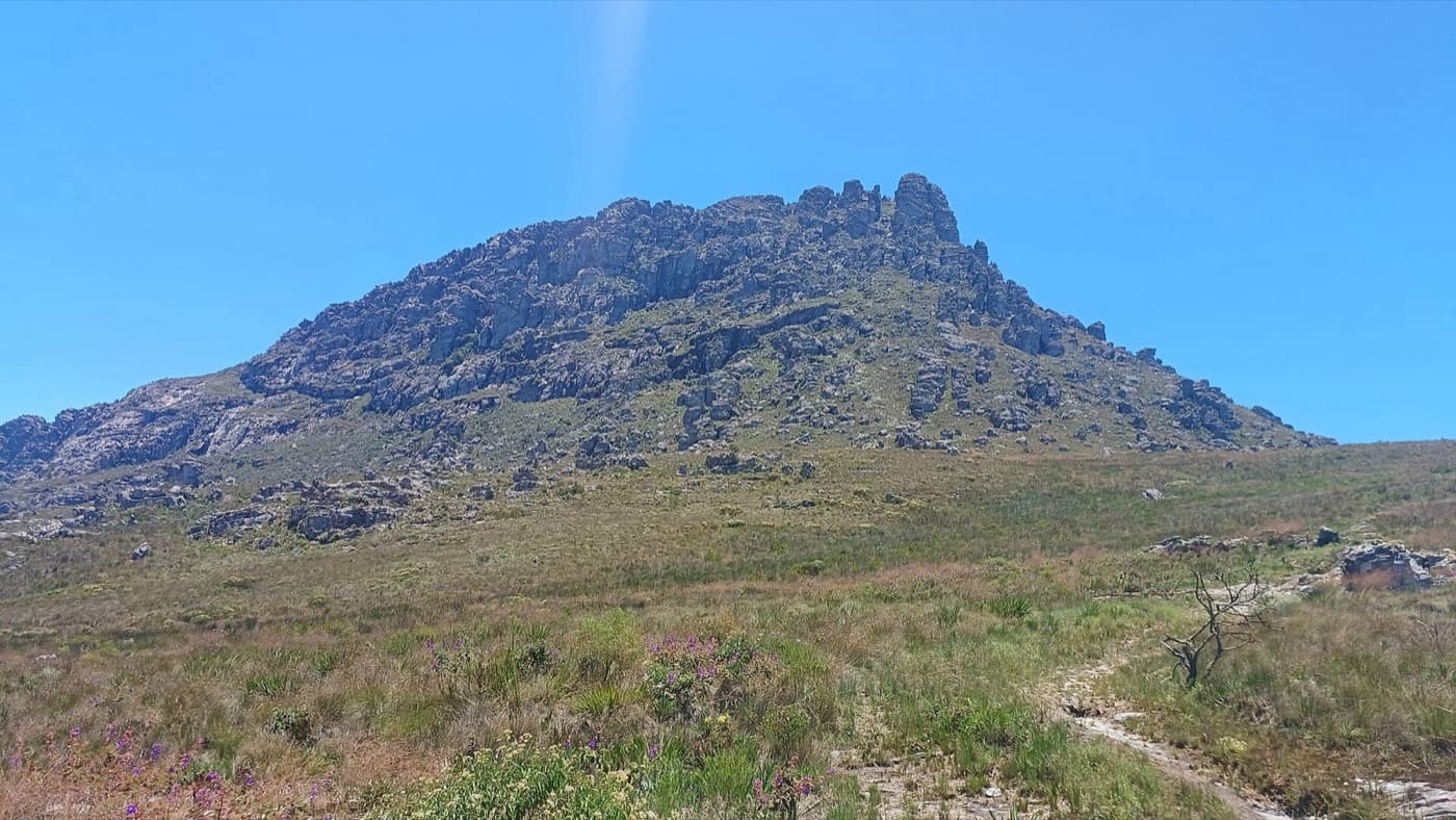 Bloco rochoso do cume do Pico do Itambé visto da trilha que atravessa os campos rupestres