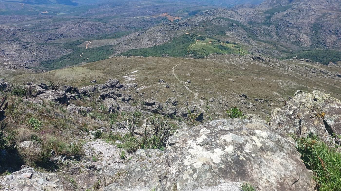 Vista do alto do Pico do Itambé sobre os campos rupestres e a trilha que desce entre as rochas
