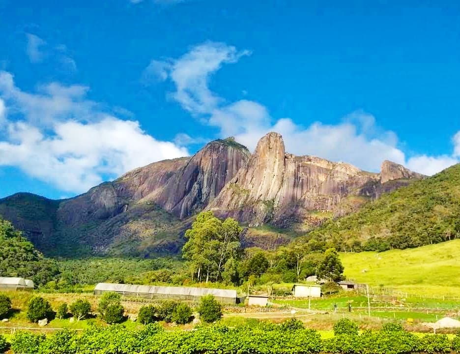 Torres de Bonsucesso vistas do vale, com lavouras, estufas e pasto em primeiro plano