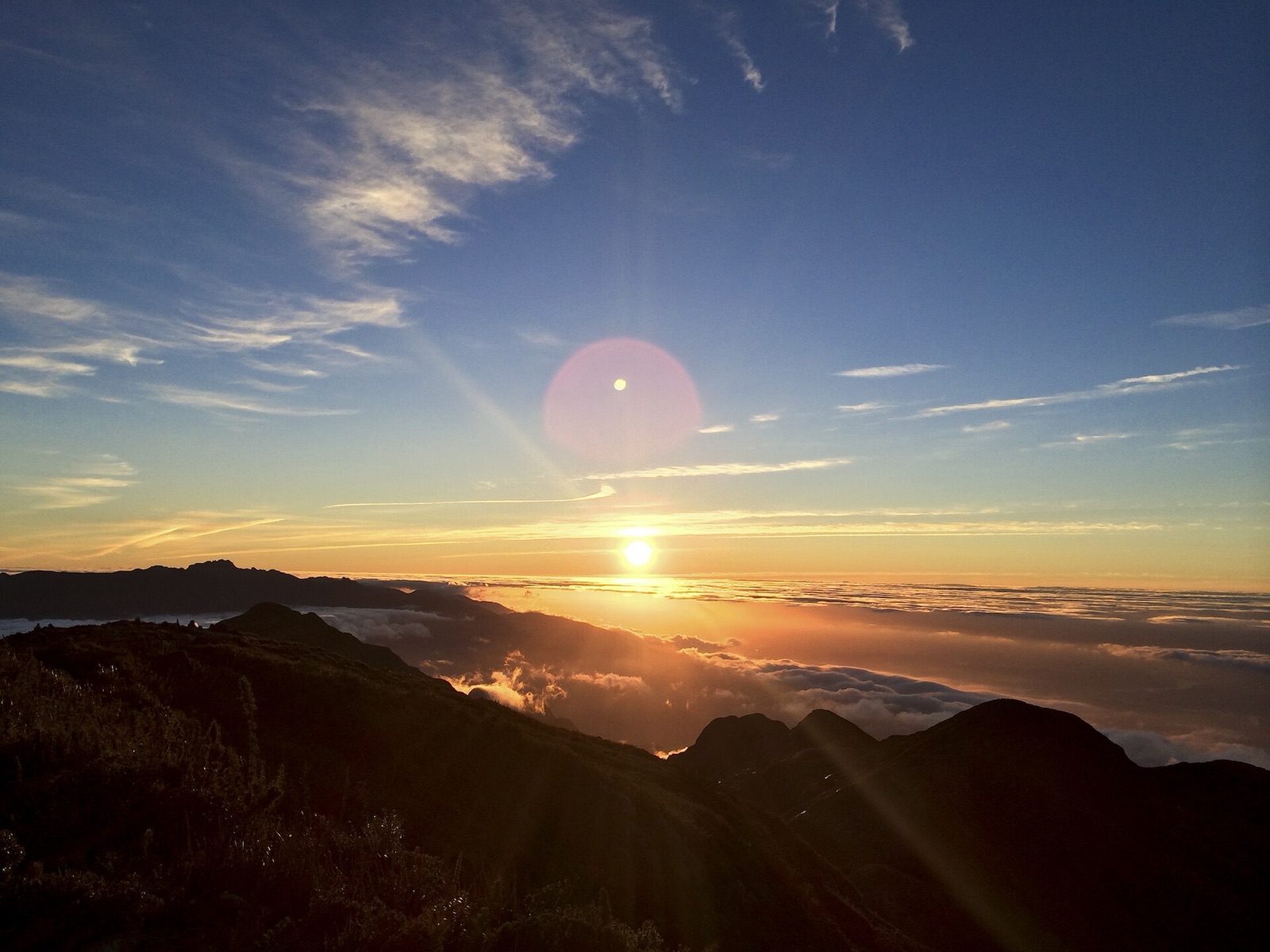 Nascer do sol visto do cume da Pedra da Mina, com mar de nuvens e o maciço das Agulhas Negras no horizonte