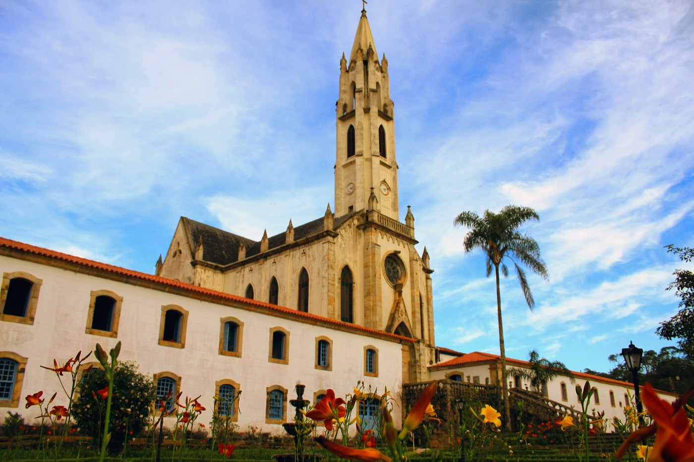 Fachada da igreja neogótica de Nossa Senhora Mãe dos Homens, no Caraça, com jardim florido à frente
